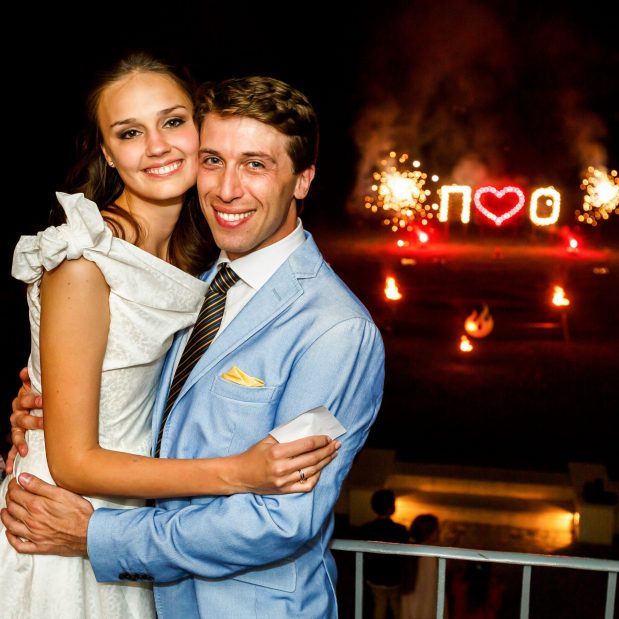 happy bride and groom  hugging smiling  on background firework  night
